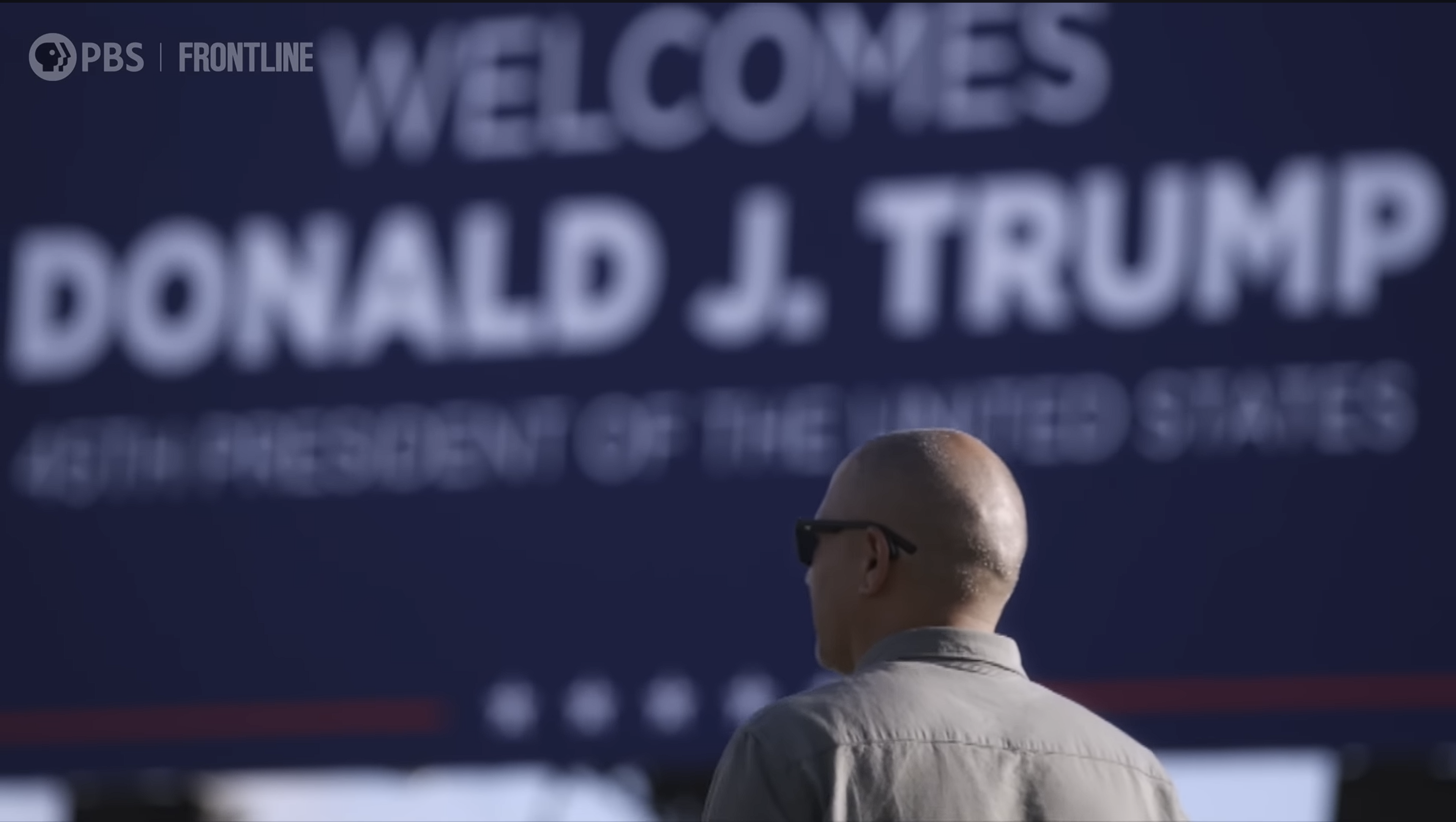 PBS FRONTLINE documentary still showing a man in front of a Donald J. Trump sign